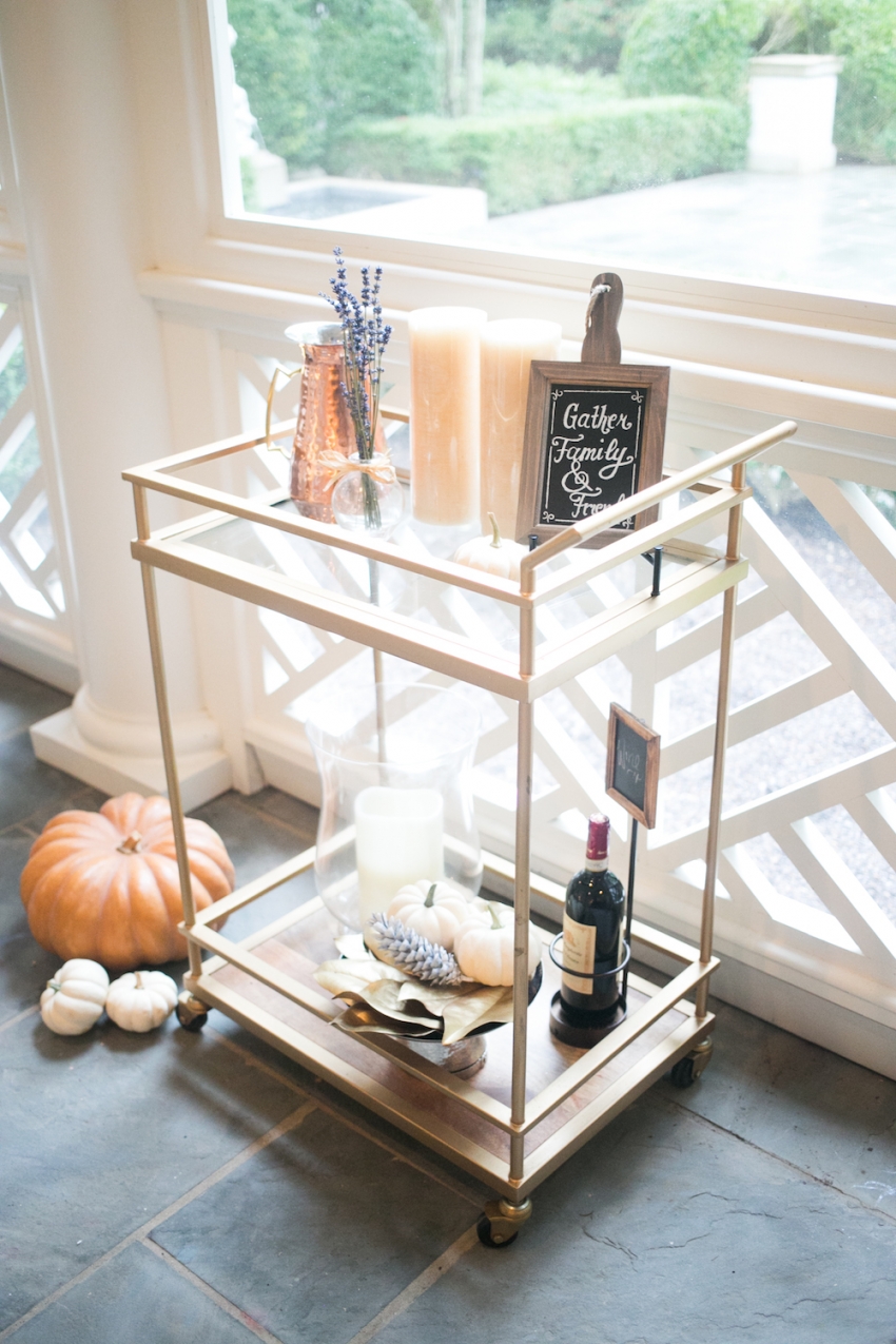 Candles, Red Wine, Pumpkins, and Chalk Board on Bar Cart on Fashionable Hostess